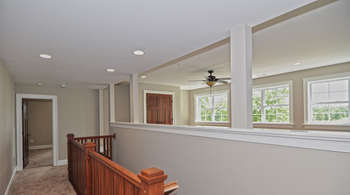 ICH Builders Mt. Sterling residence custom build second floor looking over wooden railing towards the loft area